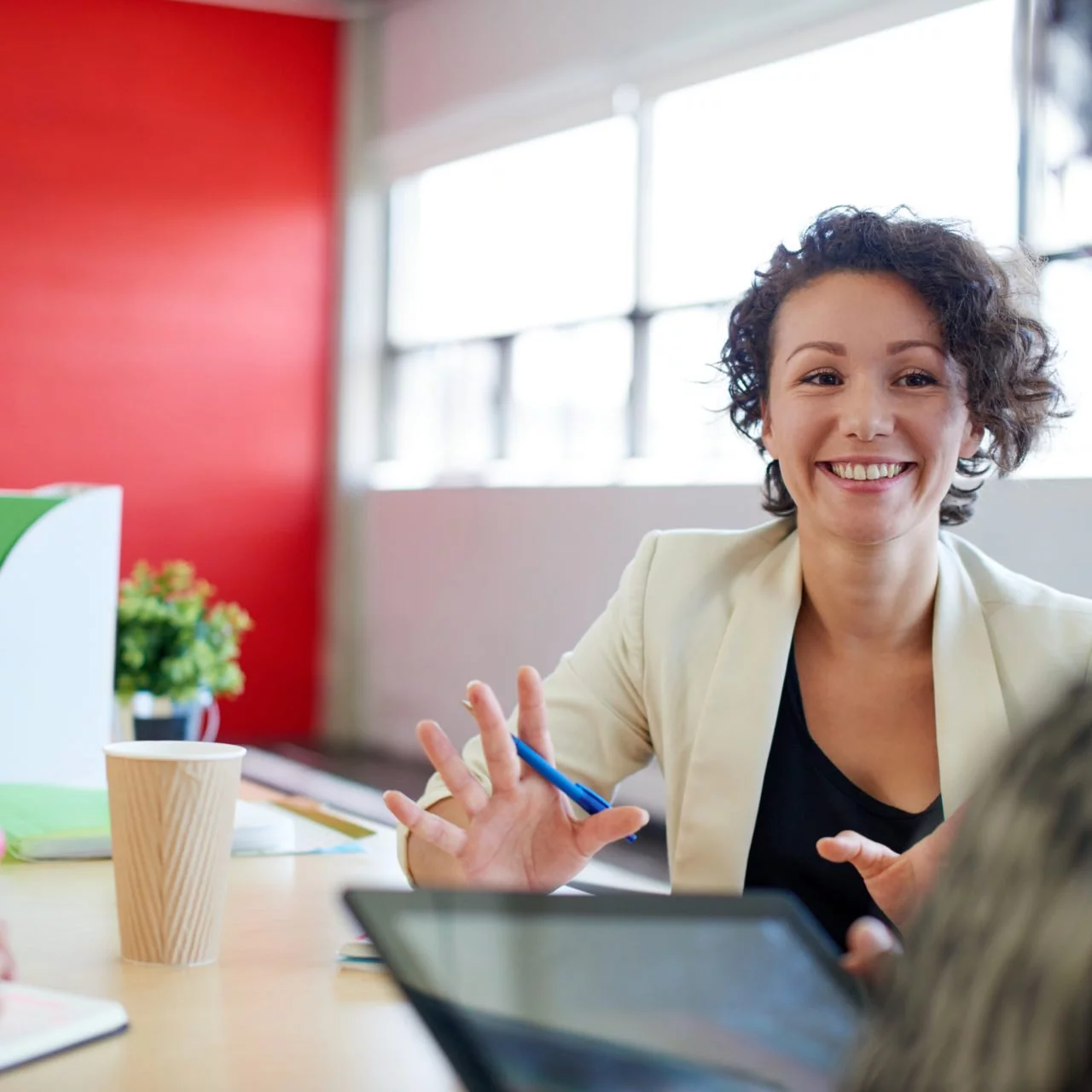 Happy female teacher reviewing notes on a tablet with a coworker